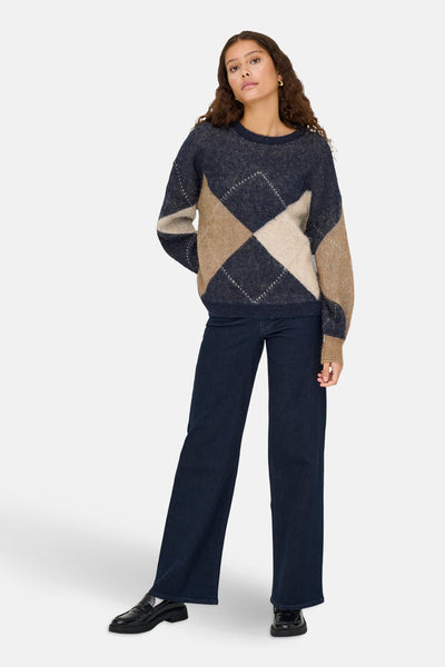 Pull multicolore à col rond de ONLY, avec motif losanges et porté avec un jean foncé.
