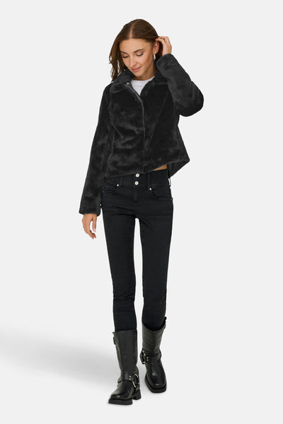 Veste courte noire en fausse fourrure de JDY, portée avec un jean noir et des bottes motardes.
