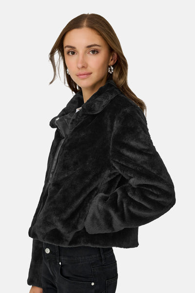 Veste courte noire en fausse fourrure de JDY, avec col à revers et fermeture à glissière visible.