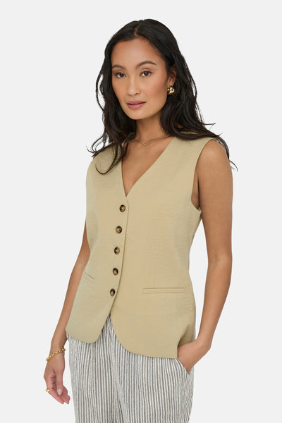 Blazer écru de JDY avec boutonnage simple, poches passepoilées et porté sur un pantalon rayé.
