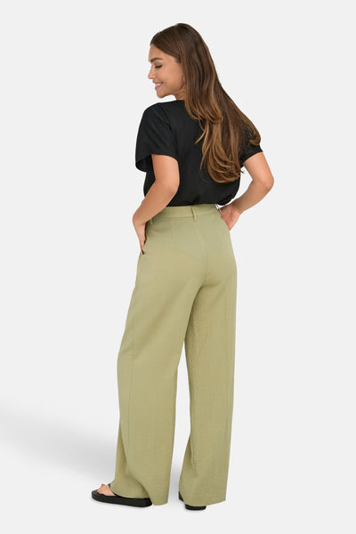 Pantalon de costume beige de JDY, coupe ample, avec une texture subtile et une personne portant un t-shirt noir.

