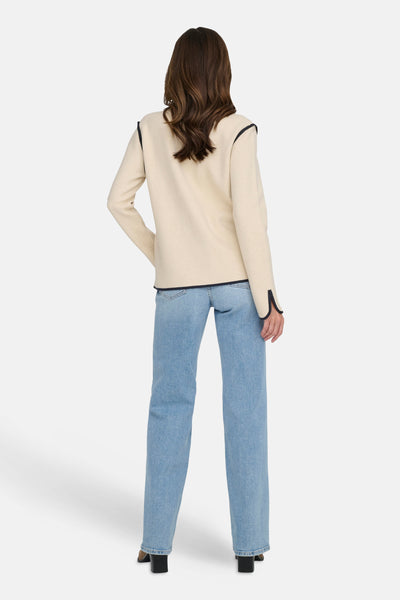 Beige blazer van JDY, met een zwarte bies, gedragen met een blauwe jeans en zwarte hakken.