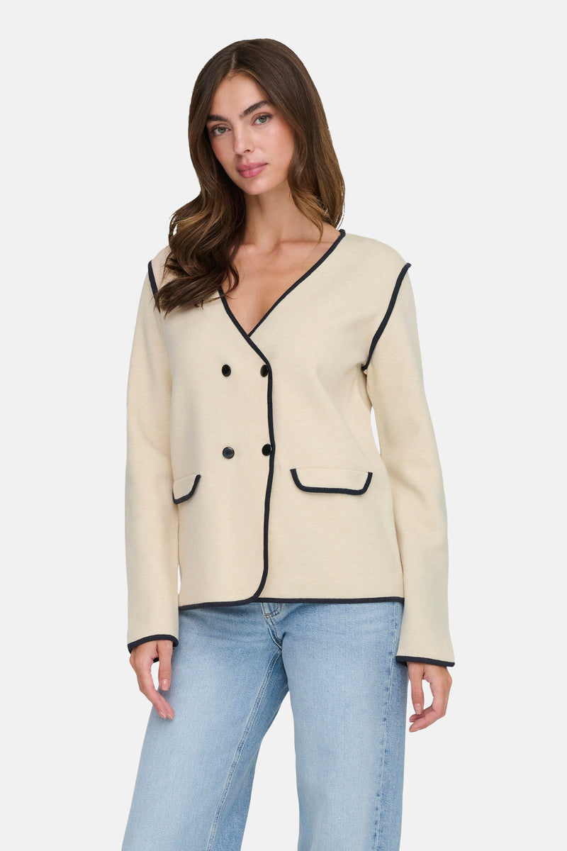 Beige blazer van JDY met een zwarte bies en een dubbele rij knopen, gedragen met een blauwe jeans.