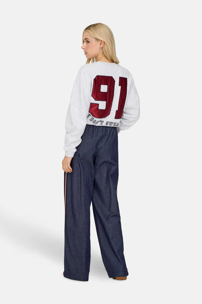 Pantalon en denim bleu foncé par ONLY®, coupe ample avec bande latérale rouge.