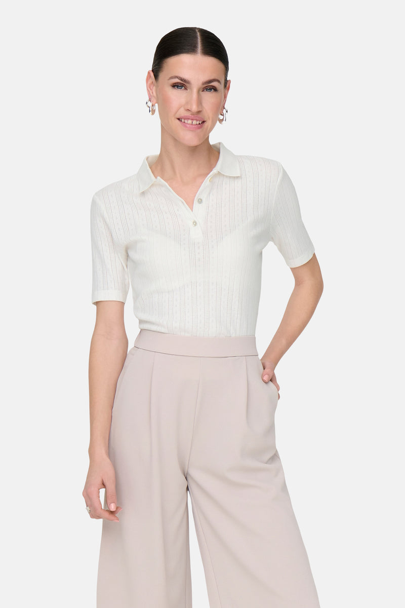 Wit poloshirt met korte mouwen van JDY, met een ajourpatroon en gedragen met een wijde beige broek.