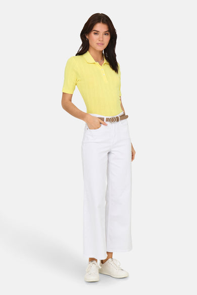 Polo jaune à manches courtes de JDY, porté avec un jean blanc et une ceinture marron.
