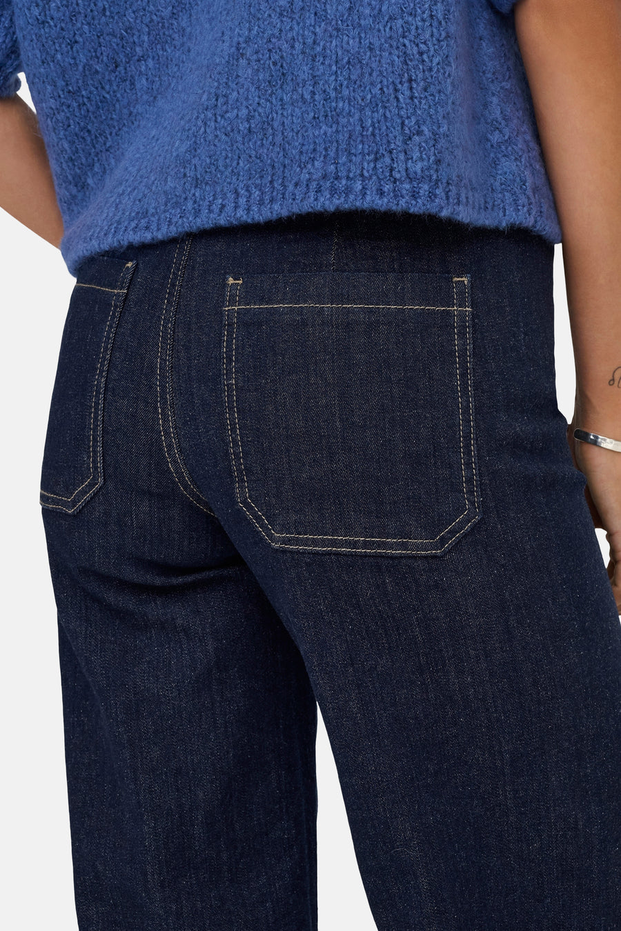 Wijde jeans in donkerblauw denim van JDY, achterzakdetails op een effen achtergrond.