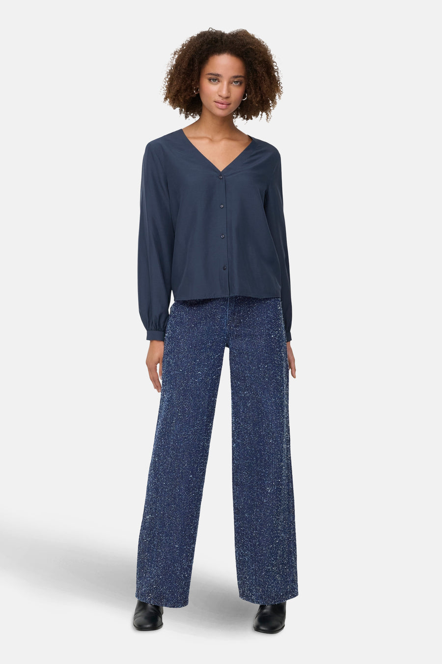 Gekleurde blauwe jeans van JDY, wijde rechte pasvorm met glanzende accenten, gedragen met een effen marineblauw overhemd.