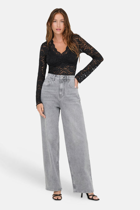 T-shirt noir à manches longues en dentelle par ONLY®, col en V, vue de face sur modèle portant jeans gris et sandales noires