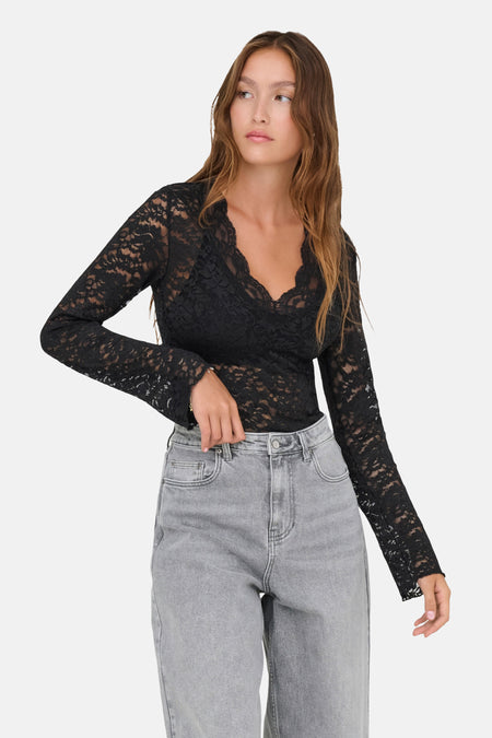T-shirt noir à manches longues en dentelle par ONLY®, col en V, porté avec un jean gris clair, vue de face.