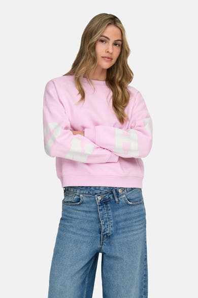 Sweat rose de ONLY, avec des manches longues décorées de rayures blanches, porté avec un jean bleu.
