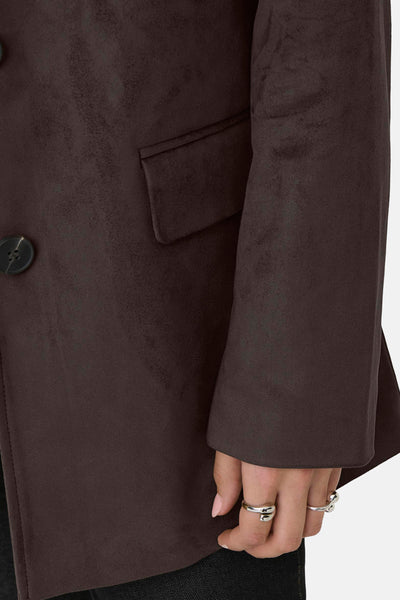Veste longue brune de ONLY, avec deux boutons, une poche passepoilée et des anneaux aux doigts.
