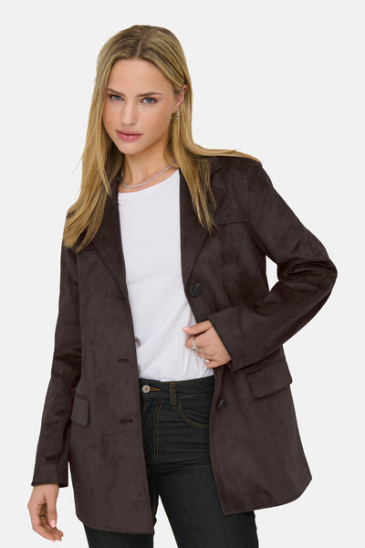 Veste longue brune de ONLY, portée avec un t-shirt blanc et un jean foncé.