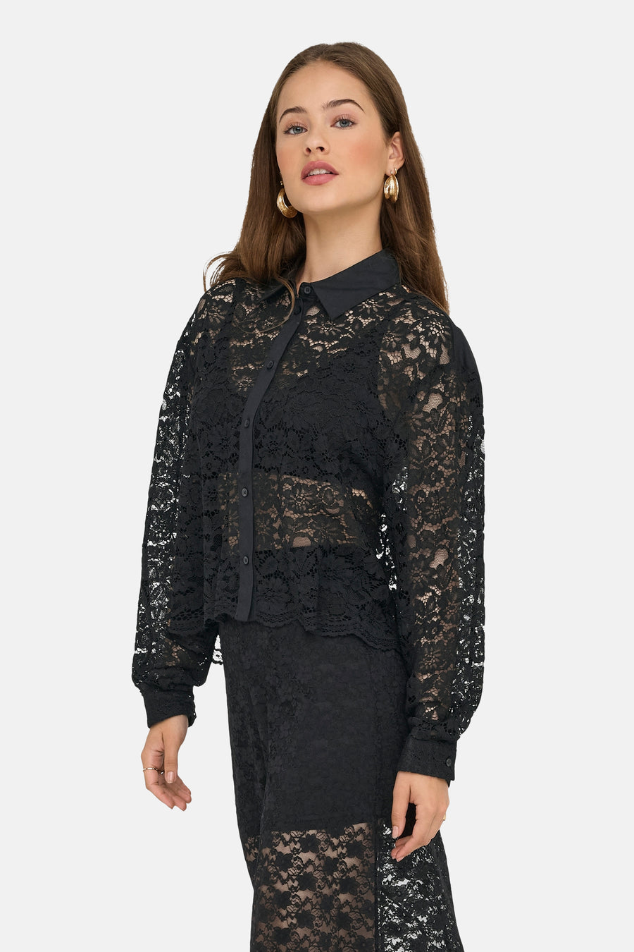 Zwarte kanten blouse van ONLY®, gedragen met gouden oorbellen.