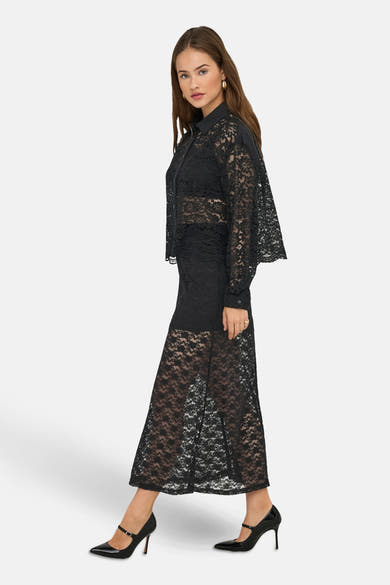 Zwarte blouse van ONLY, van doorschijnend kant met een bijpassende lange rok en zwarte pumps.