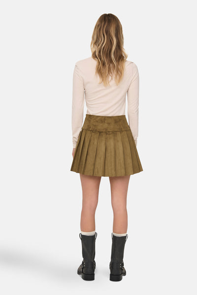 Korte bruine rok ONLY®, geplooide pasvorm, gedragen met een beige top met lange mouwen en zwarte laarzen.