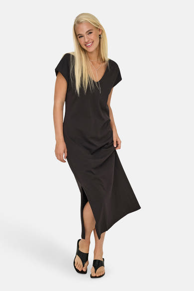 Robe longue marron de ONLY®, avec col en V et fente sur le côté, portée avec des sandales noires.