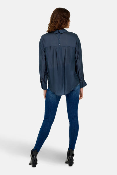 Blauwe blouse met lange mouwen van JDY, met knoopsluiting aan de achterkant, gedragen met een spijkerbroek en zwarte enkellaarsjes.