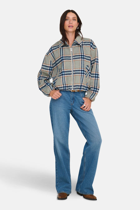 Veste courte multicolore de ONLY, avec motif à carreaux, portée avec un jean et des bottes marron.