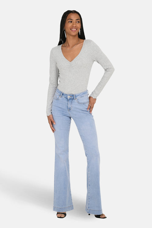 Jean évasé bleu clair de ONLY, porté avec un haut à manches longues et un collier argenté.
