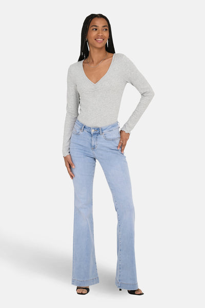 Jean évasé bleu clair de ONLY, porté avec un haut à manches longues et un collier argenté.
