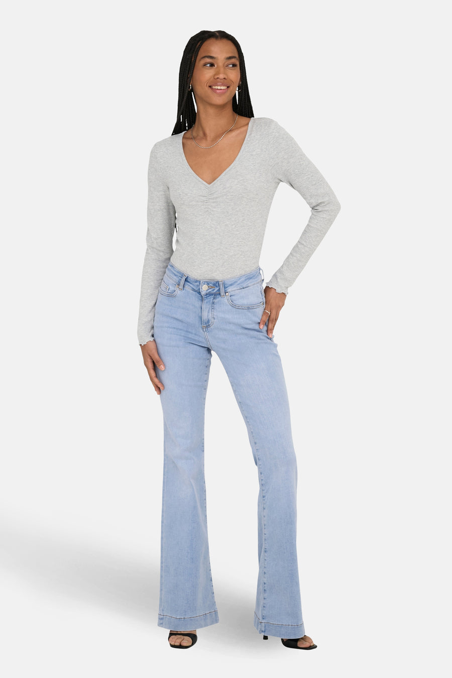 Jean évasé bleu clair de ONLY, porté avec un haut à manches longues et un collier argenté.
