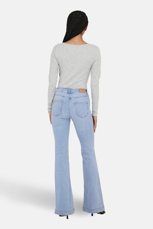 Jean évasé en denim bleu clair de ONLY, porté avec un haut gris à manches longues.
