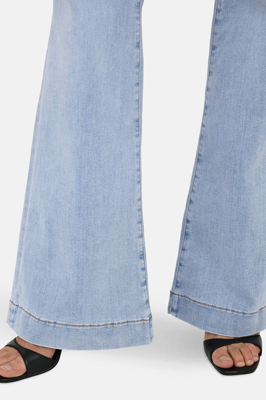 Wijd uitlopende jeans in lichtblauw denim van ONLY, met gestikte zoom en gedragen met zwarte muiltjes.