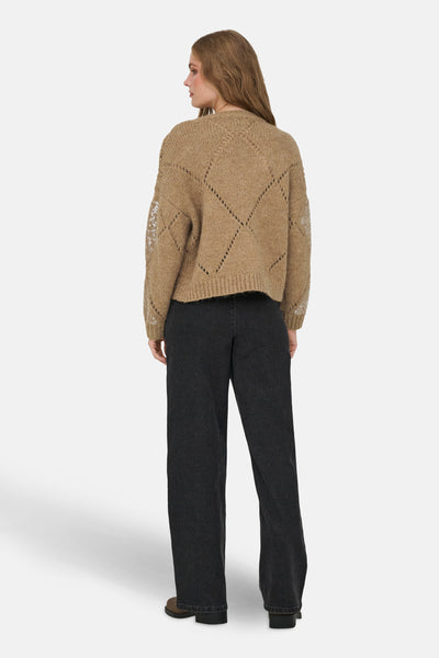 Pull à col rond beige de ONLY, avec des motifs ajourés en losange et des détails pailletés sur les manches.