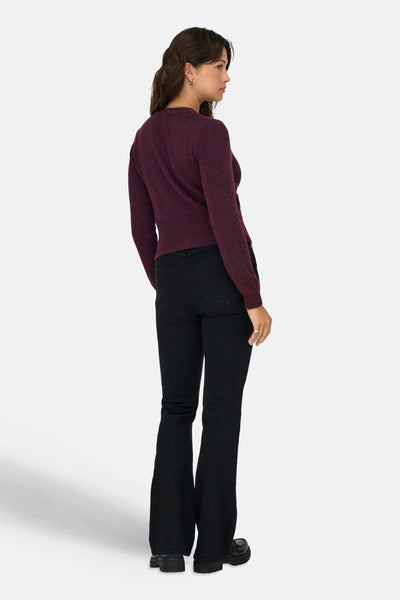 Bordeaux gebreid vest, van ONLY, gedragen met een zwarte flared jeans en dikke schoenen.
