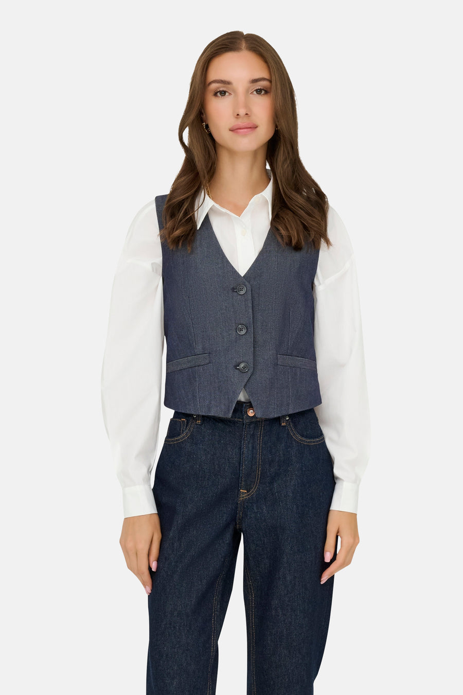 Donkerblauwe spijkerblazer van JDY, gedragen over een wit overhemd met lange mouwen en een donkerblauwe broek.