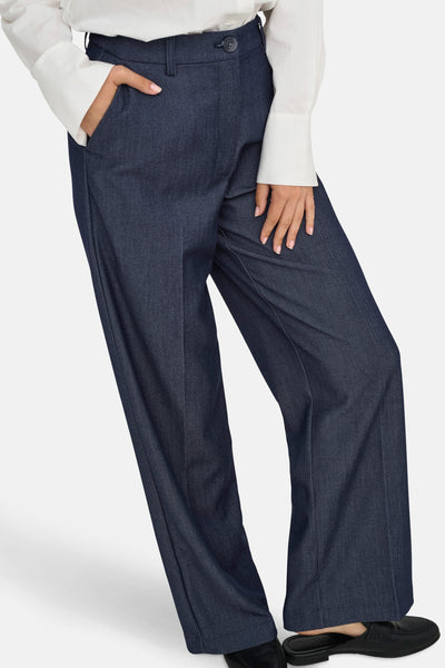 Pantalon de costume bleu denim foncé de JDY, coupe large, avec une chemise blanche et des mocassins noirs.
