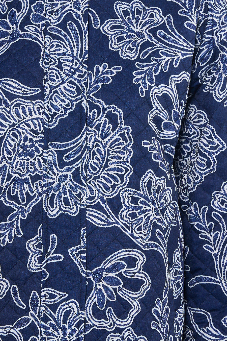 Veste courte bleue de JDY avec motif floral blanc et texture matelassée.