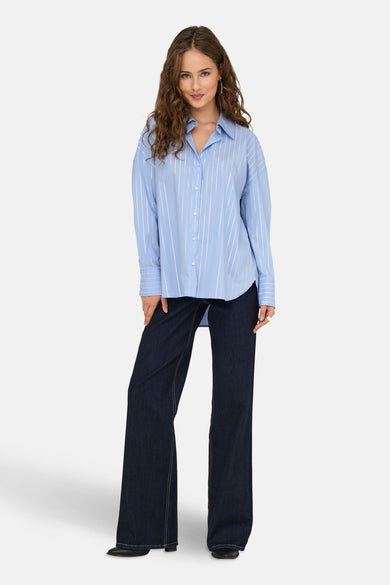 Blauwe gestreepte blouse met lange mouwen van JDY, gedragen met een high-waisted flared jeans en zwarte schoenen.