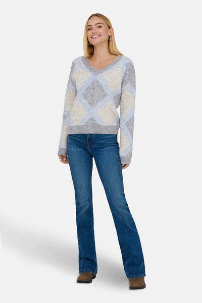 Pull à col en V multicolore de JDY, à motif losanges, porté avec un jean et des bottines marron.
