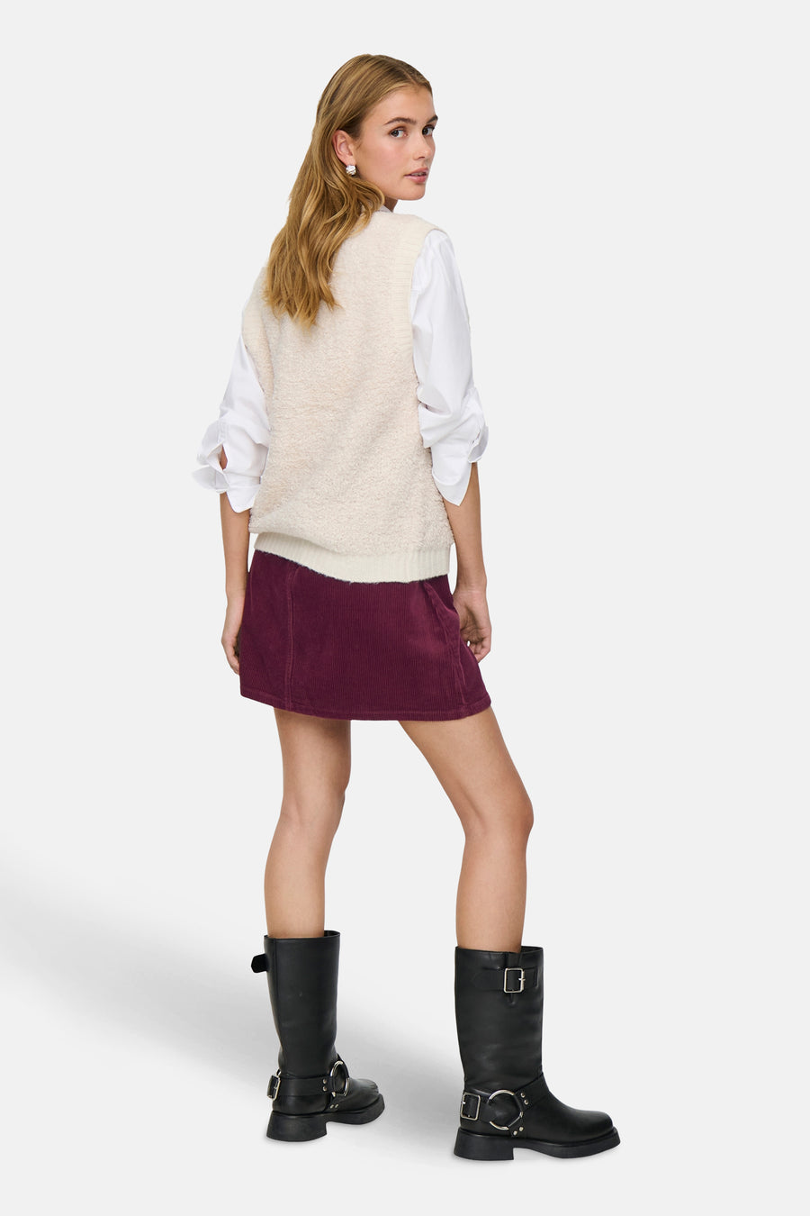 Débardeur écru de JDY, porté sur une chemise blanche à manches longues et une jupe bordeaux.
