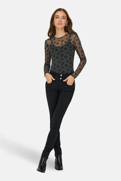 T-shirt à manches longues gris de JDY, motif fleuri noir sur maille transparente, porté avec un jean noir taille haute.