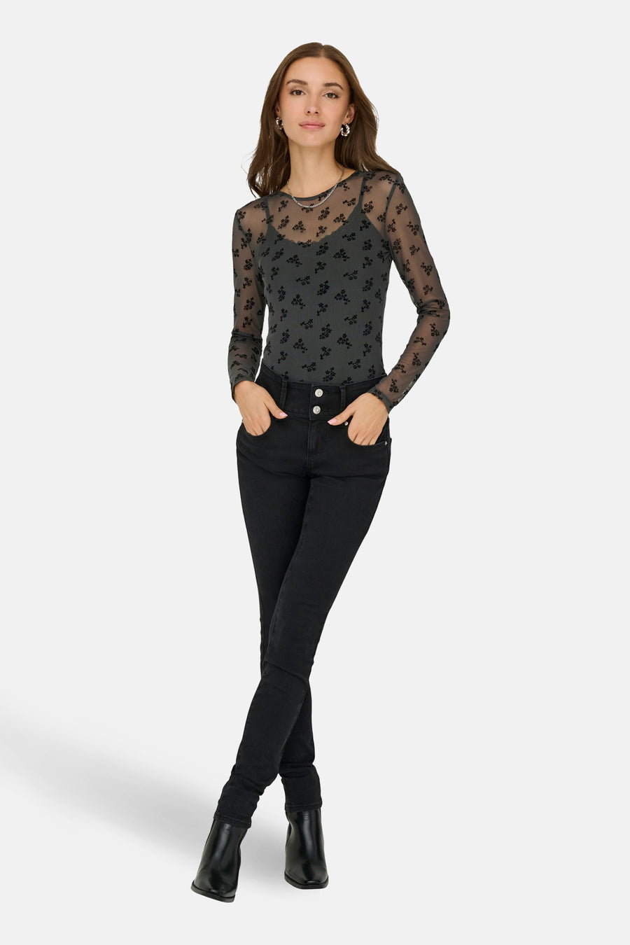 T-shirt à manches longues gris de JDY, motif fleuri noir sur maille transparente, porté avec un jean noir taille haute.