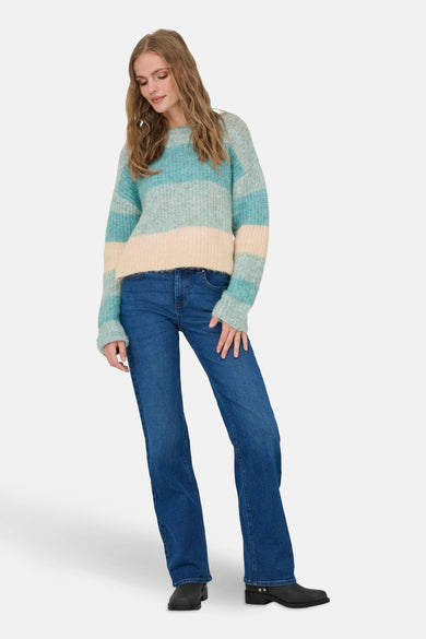 Pull à col rond bleu van JDY, porté avec un jean bleu et des bottes noires.