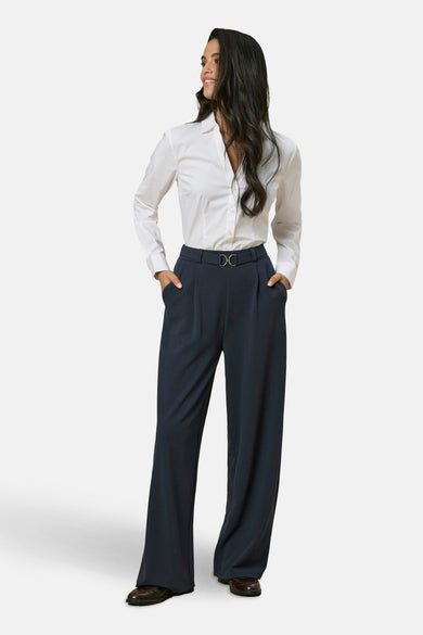 Zwarte broek JDY, wijde pasvorm met hoge taille en een gouden gespceintuur, gedragen met een wit overhemd.