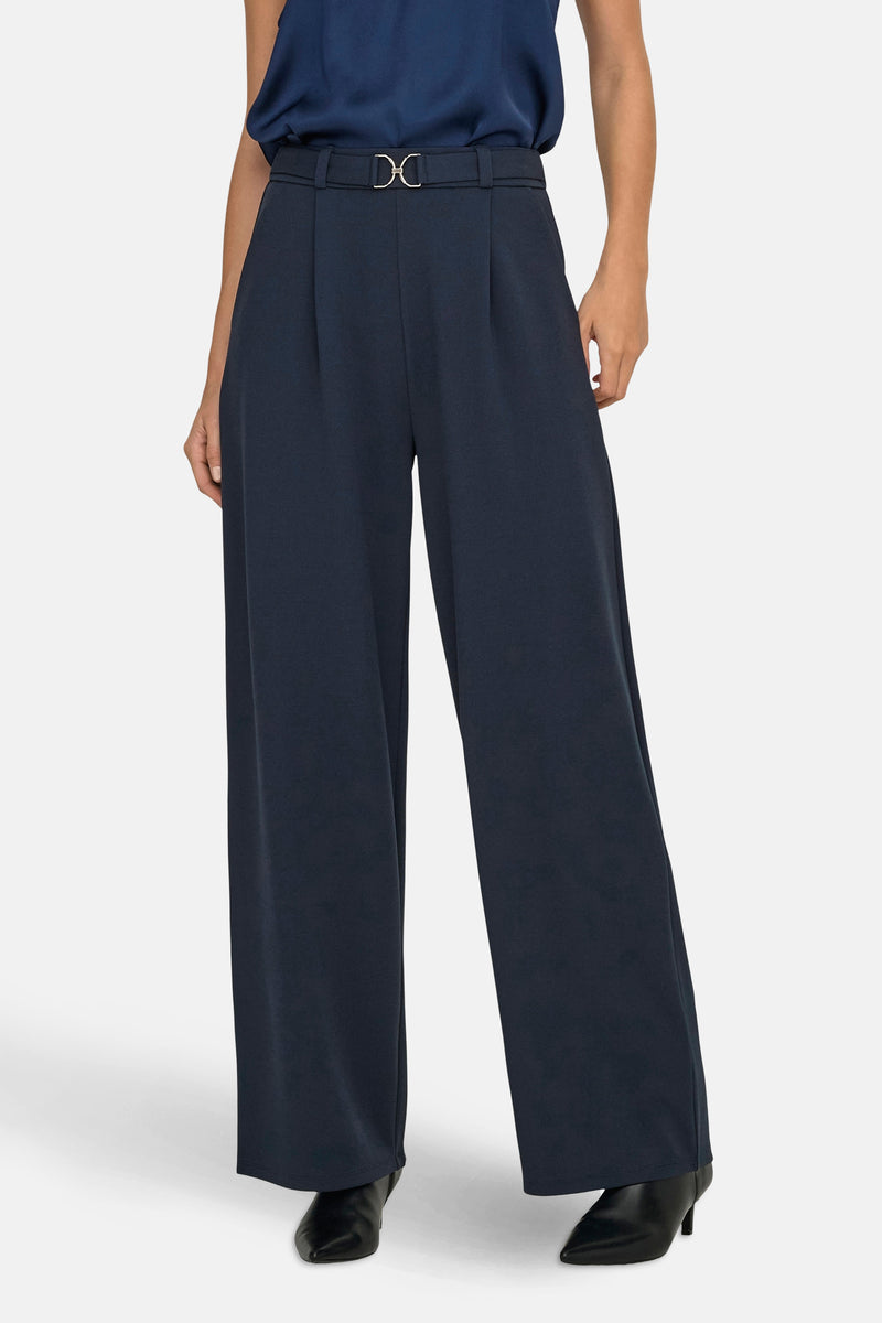 Blauwe broek van JDY, losse pasvorm met een decoratieve riem en gedragen met een marineblauwe top.