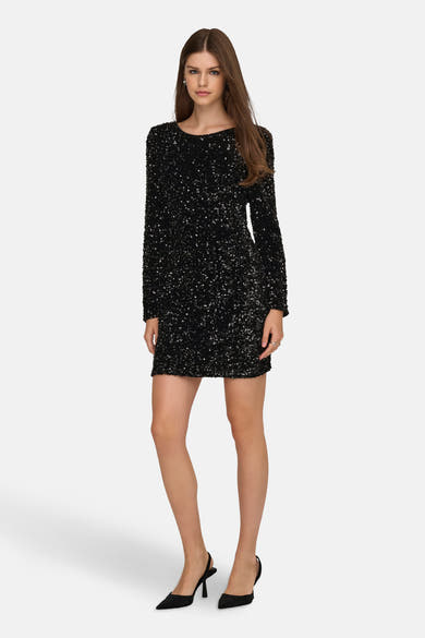 Robe noire à manches longues de ONLY, ornée de paillettes brillantes et portée avec des escarpins noirs.
