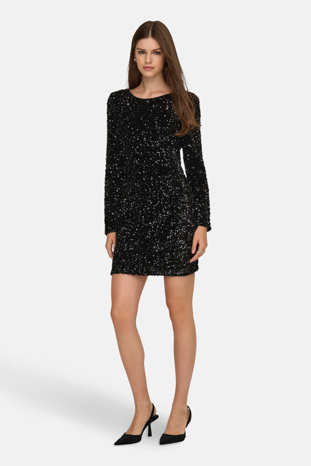 Robe noire à manches longues de ONLY, ornée de paillettes brillantes et portée avec des escarpins noirs.
