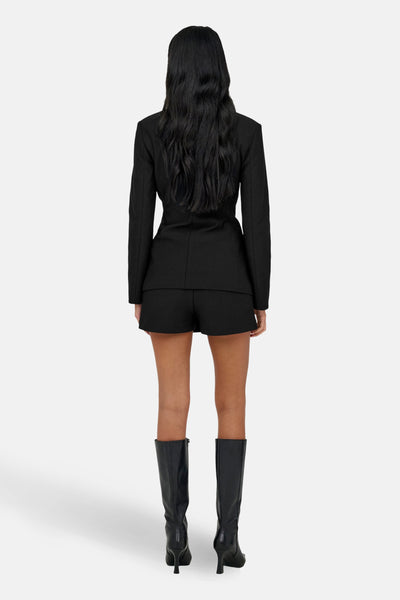 Blazer noir de ONLY, porté avec des shorts et des bottes noires, vue de dos.

