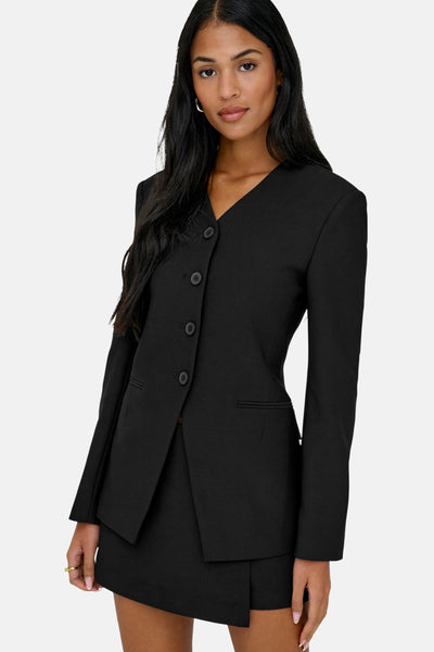 Zwarte blazer van ONLY®, met asymmetrische snit en knoopsluiting, gedragen met een bijpassende rok.