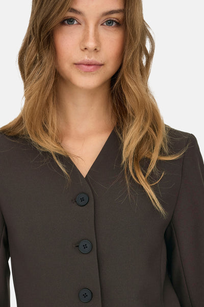 Bruine blazer van ONLY met een drieknoopssluiting, gedragen door een model met golvend haar.