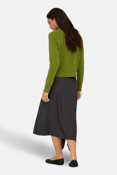 Groene cardigan van ONLY®, gedragen met een gestreepte rok en platte schoenen.