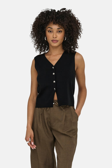 Zwarte bodywarmer van JDY met zilveren knopen, gedragen met een bruine broek met trekkoord.