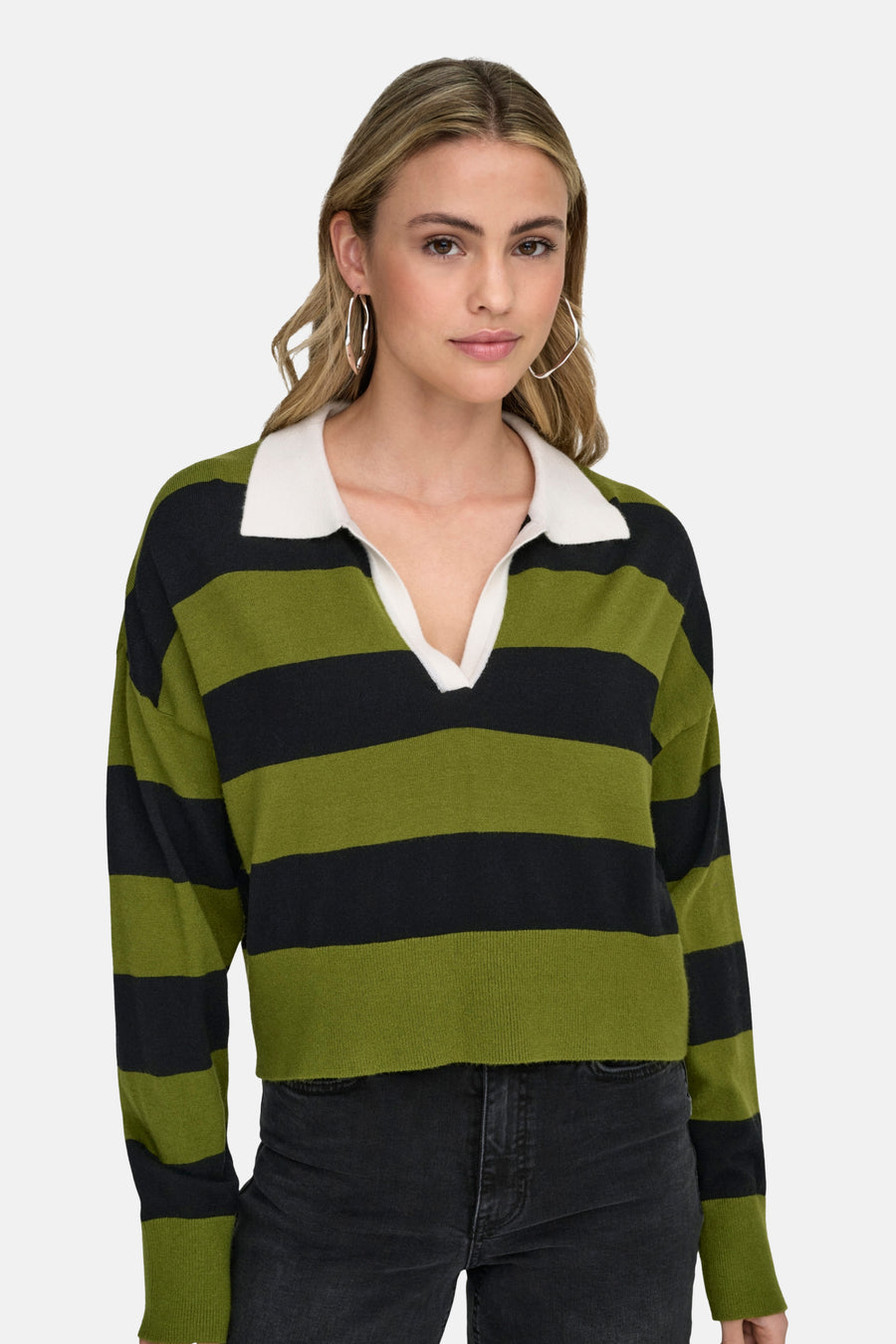 Groene trui met zwarte strepen van ONLY, gedragen met een zwarte jeans en zilveren oorbellen.