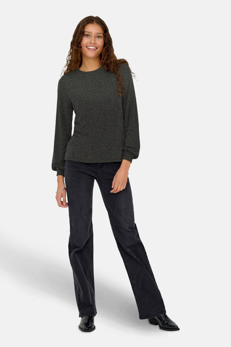 Chemisier noir à manches longues de ONLY, avec un motif géométrique subtil, porté avec un jean noir et des bottines.
